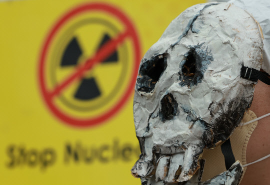 3월 9일 중구 서울파이낸스센터 앞에서 열린 '탈핵 행동의 날' 집회에서 환경운동연합 등 시민사회·환경단체 회원들이 정부의 핵 진흥 정책과 일본의 후쿠시마 원전 오염수 방류를 반대하며 탈을 쓴 채 손팻말을 들어보이고 있다. <연합뉴스>